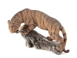 figurine représentant un tigre posé sur une souche d'arbre, sur fond blanc