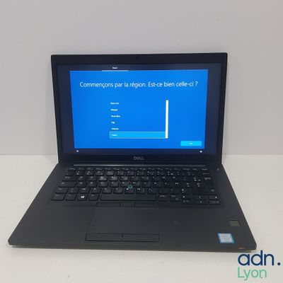 laptop computer sitting on top of a white table with a blue screen