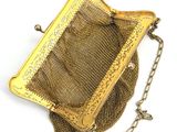 an antique gold mesh purse with a chain around it