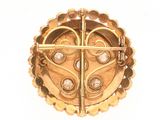 an image of a gold broochle with a cross on it