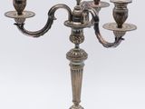 an antique silver plated candelab with five candles on a stand