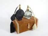 two perfume bottles sitting on top of an old suitcase