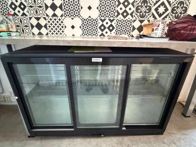 two glass door refrigerators sitting on top of a counter in a kitchen