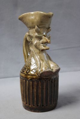 a small vase with a cat in it on a table