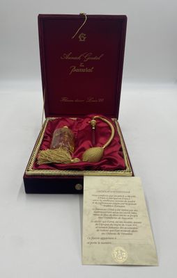 une boîte rouge contenant une pipe dorée et un mot