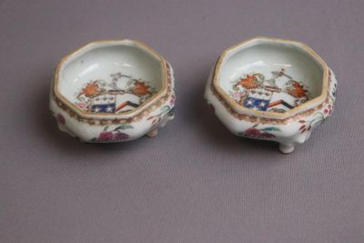 pair of porcelain bowls with flowers and birds on them on a table
