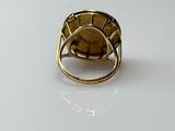 an image of a gold ring on a white surface
