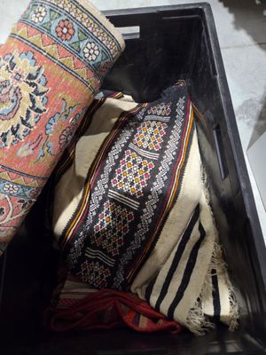 Un lot de tapis divers, dans une caisse.