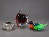 three glass birds sitting next to each other on a table