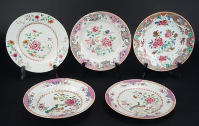 four plates with floral designs on them on a black surface