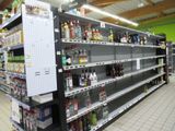 many empty shelves in the store with alcohol on them