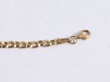 a close up of a gold chain on a white surface
