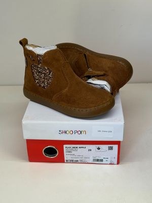 des chaussons pour bébé marron à pois, ornés de paillettes, posés sur une boîte