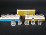 six salt and pepper shakers and a box of salt and pepper shakers