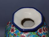 a blue and white vase with a flower pattern on it
