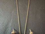 a necklace and earring set on a black surface