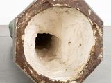 a close up of a vase with a hole in it
