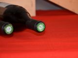 two bottles of wine sitting on a red table