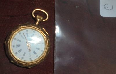 une montre de poche en or avec des chiffres romains
