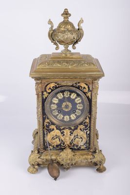 une horloge posée sur une table, sur fond blanc