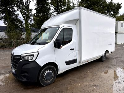 une camionnette blanche garée sur un parking, avec des arbres en arrière-plan