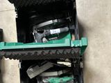 une boîte verte posée par terre, contenant des outils