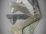 five different types of knives on a white surface