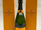 une bouteille de champagne à côté d'un carton de vin