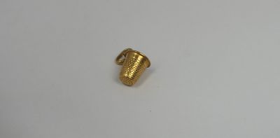 a close up of a gold plated object on a white surface
