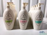 four bottles of body wash sitting on top of a white counter