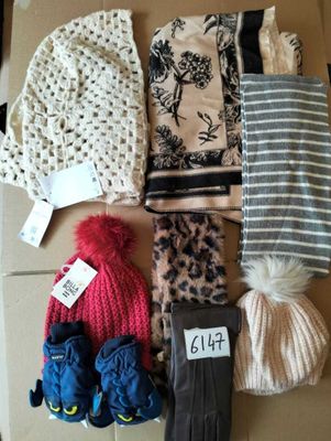 de nombreux bonnets et gants posés sur une boîte munie d'une étiquette de prix