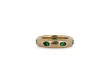 a gold ring with emerald stones