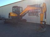 a picture of a small excavator parked in front of a building