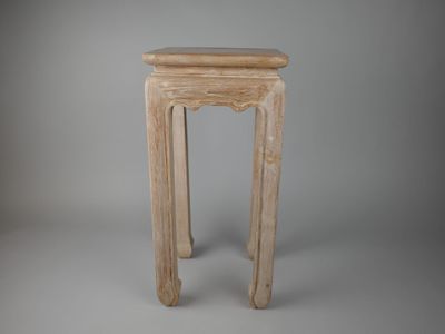 une petite table avec un plateau en bois sur fond gris