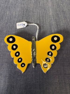 un gros plan d'un papillon jaune aux ailes tachetées de noir