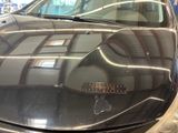 a car that is parked in a garage with its hood up