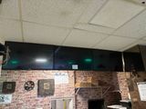 un mur en briques dans un restaurant, avec une horloge accrochée au mur