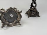 two small metal objects sitting on a white surface