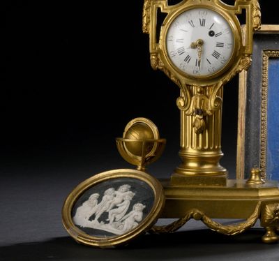 une horloge en or posée à côté d'une photo d'un homme