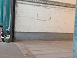 a skateboarder doing a trick on the sidewalk in front of a building