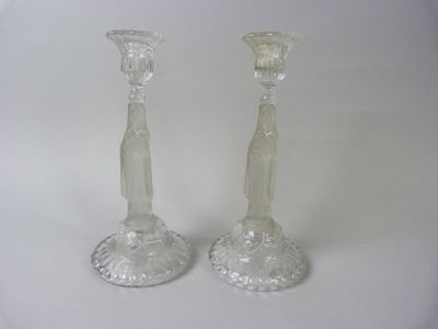 pair of clear glass candlesticks on a white background