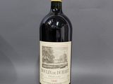 une bouteille de vin rouge avec un bouchon rouge posée sur une table