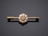 a close up of a gold and pearl hair clip on a black surface