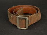 brown leather belt with a metal buckle on a black background