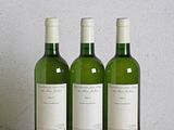 trois bouteilles de vin posées sur une table en bois
