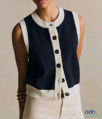 une femme qui pose pour une photo, vêtue d'un gilet