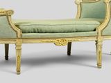 a green and gold bench with a green cushion on it