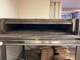 a pizza oven with pizza boxes stacked on top of it
