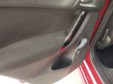 a red car door handle with a hole in it