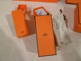 une boîte orange avec un sac blanc et une petite boîte orange sur laquelle est posé un sac blanc